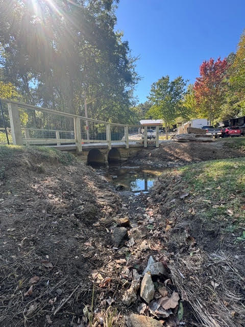 A wooden bridge crossing over a shallow stream.
